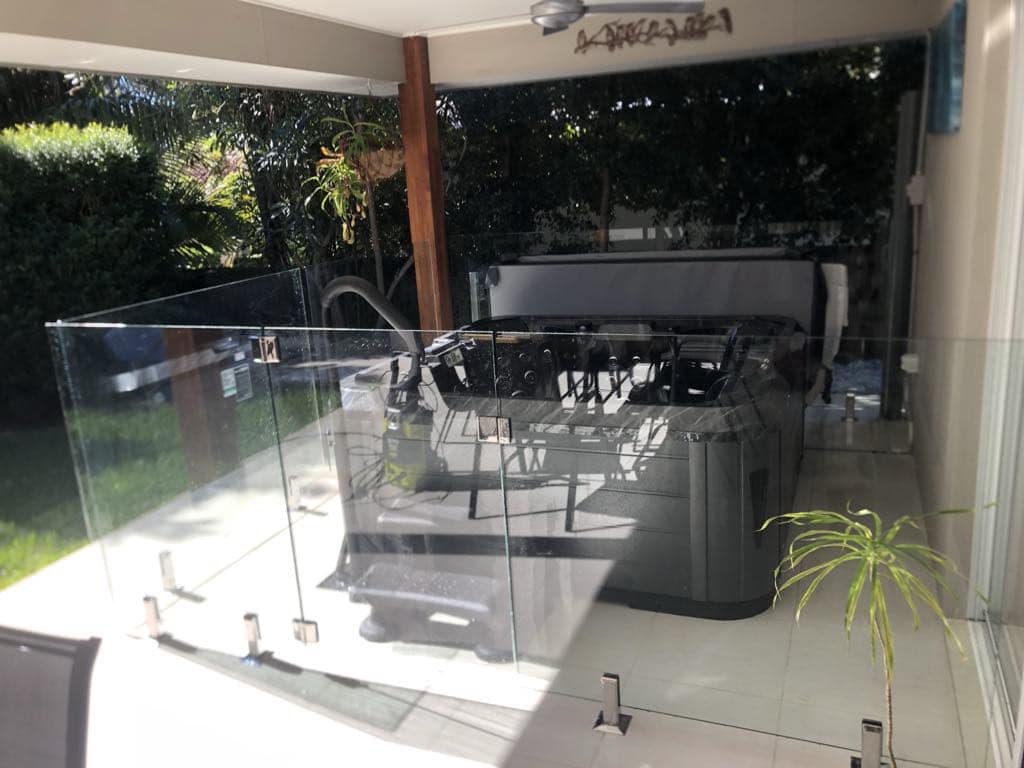 Frameless glass fence enclosing a spa with stainless spigots
